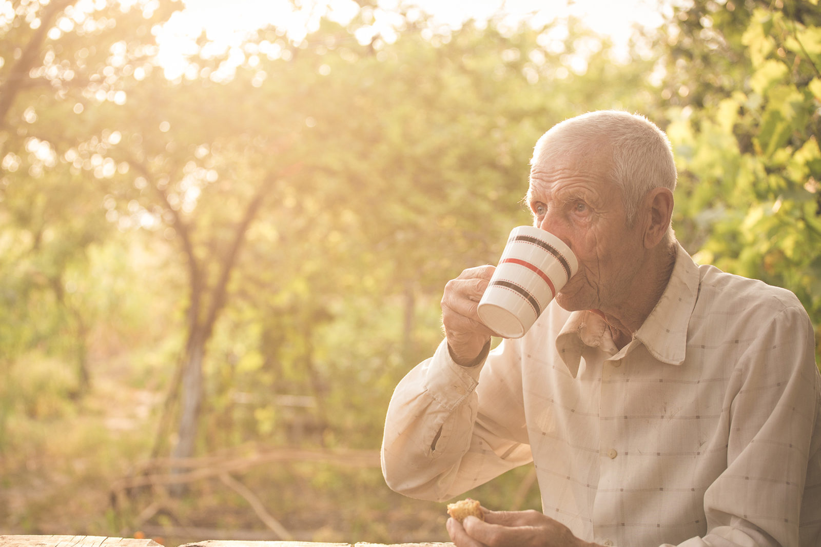Senior man drinking a tea in his garden adjusting to retirement