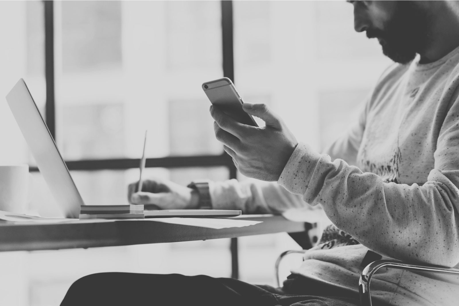 Man taking notes from his phone whilst writing a safety plan