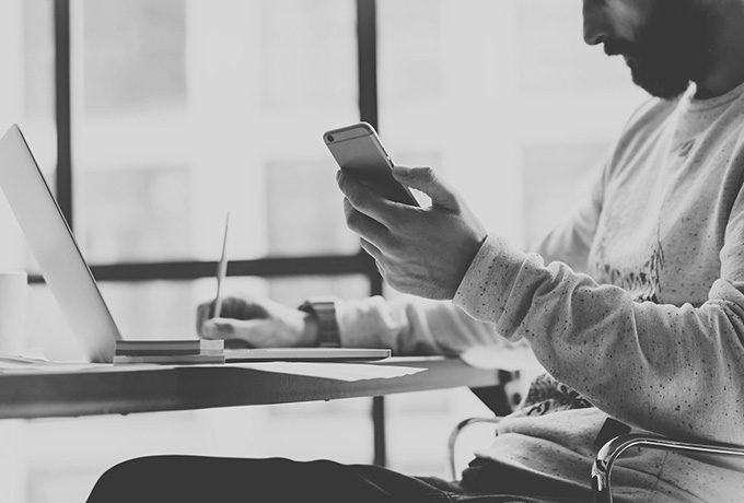 Man taking notes from his phone whilst writing a safety plan