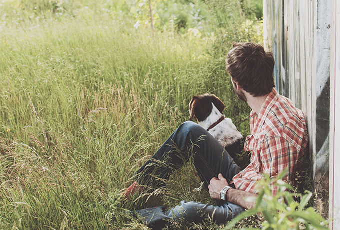 Man sat with dog in a field