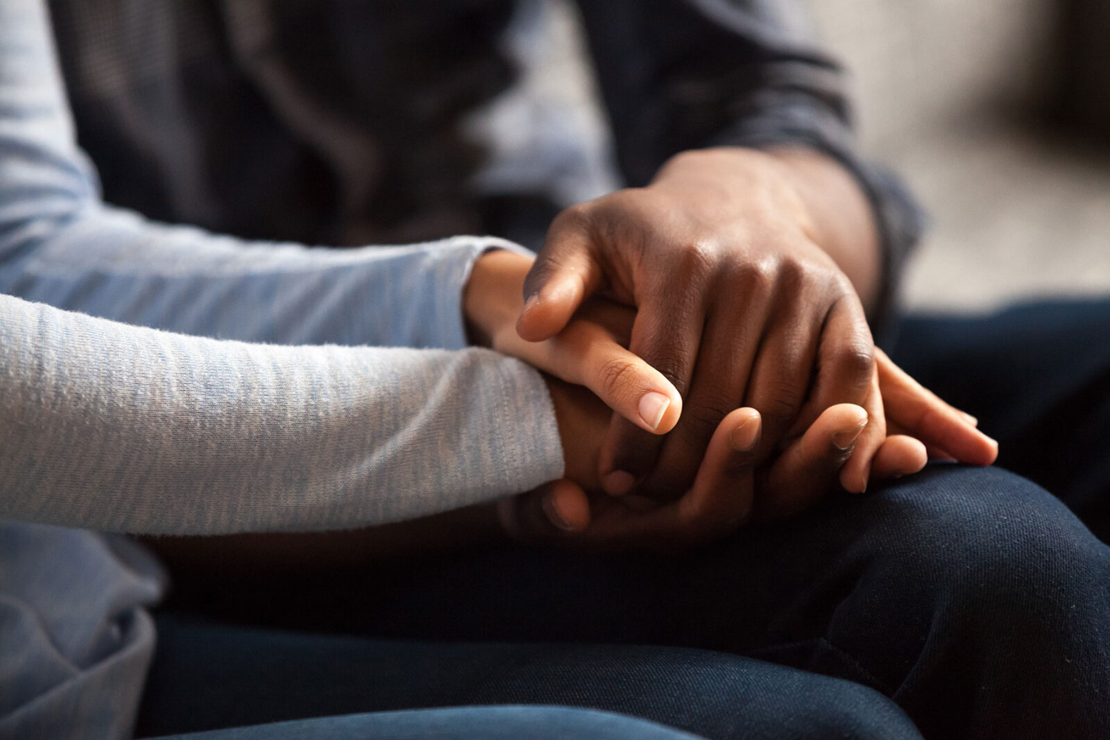 Two friends holding hands offering support